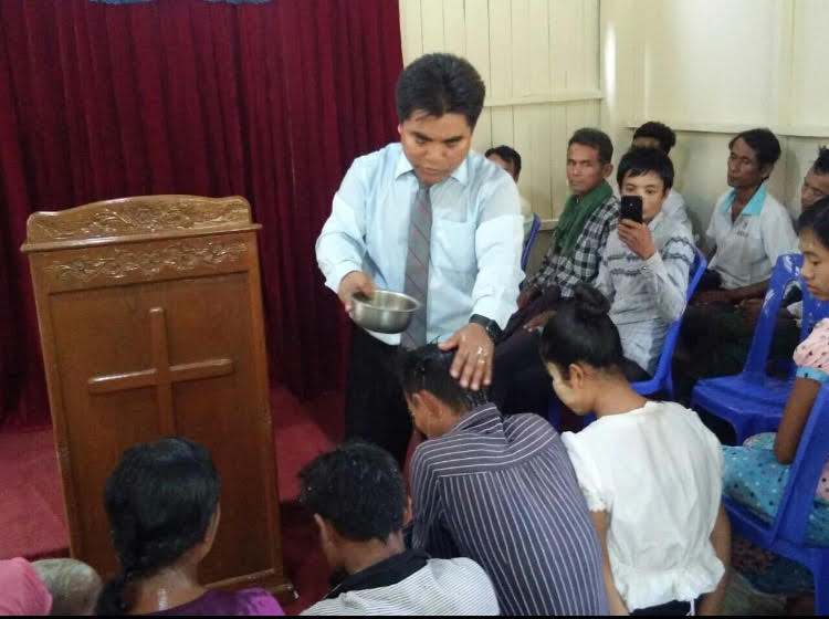 Pastor Naing baptizing new converts at the church in Bogalay, Rakhine